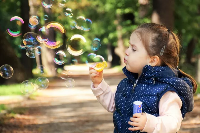 Photo of little girl blowing bubbles