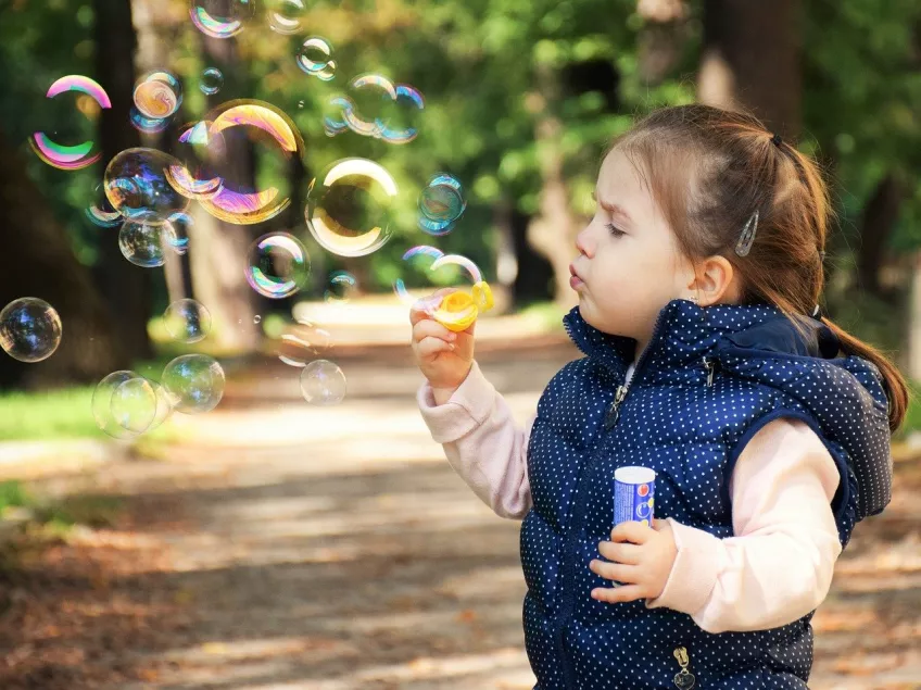Photo of little girl blowing bubbles