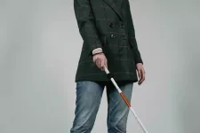 En blind person går med blindkäpp. foto